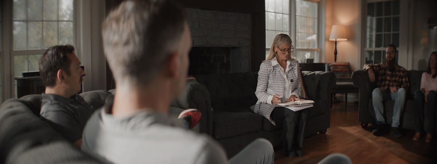 Adults gathered together in a comfortable room for a community support meeting