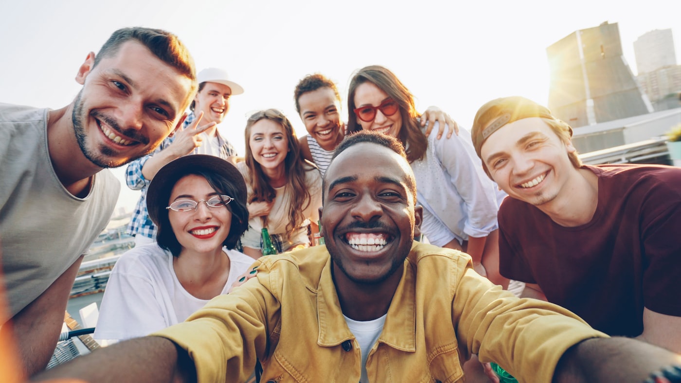 A diverse group of friends smiling together outdoors at a Hearthwell community gathering