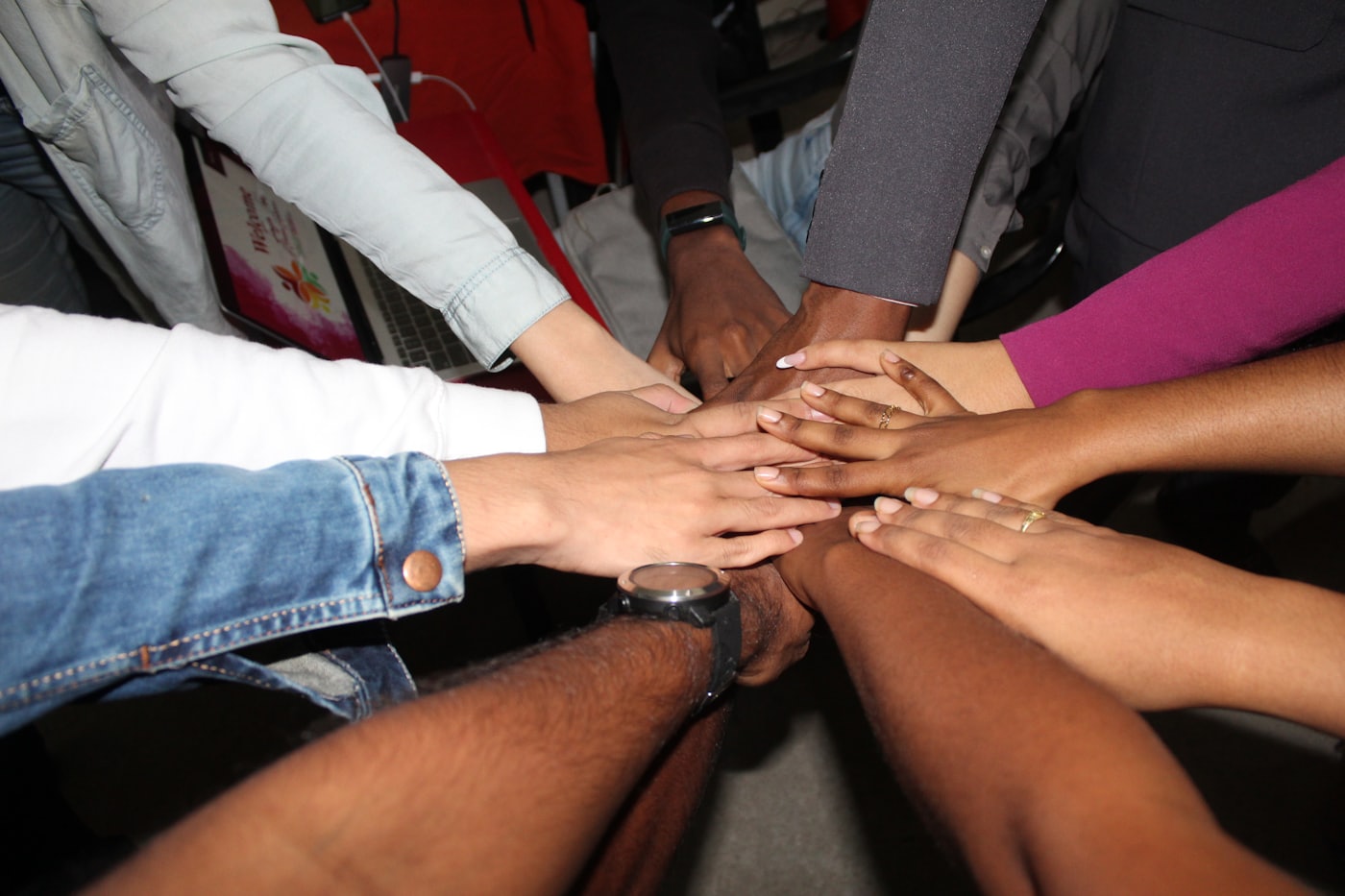 A team stacking hands together in unity, representing partnership and collaboration