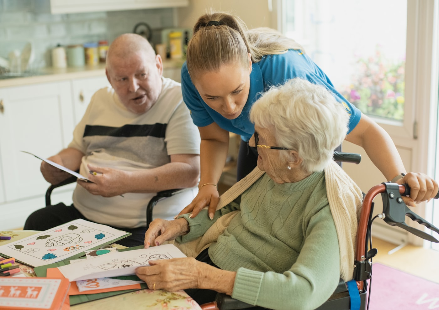 A caregiver helping an elderly person enjoy an activity together